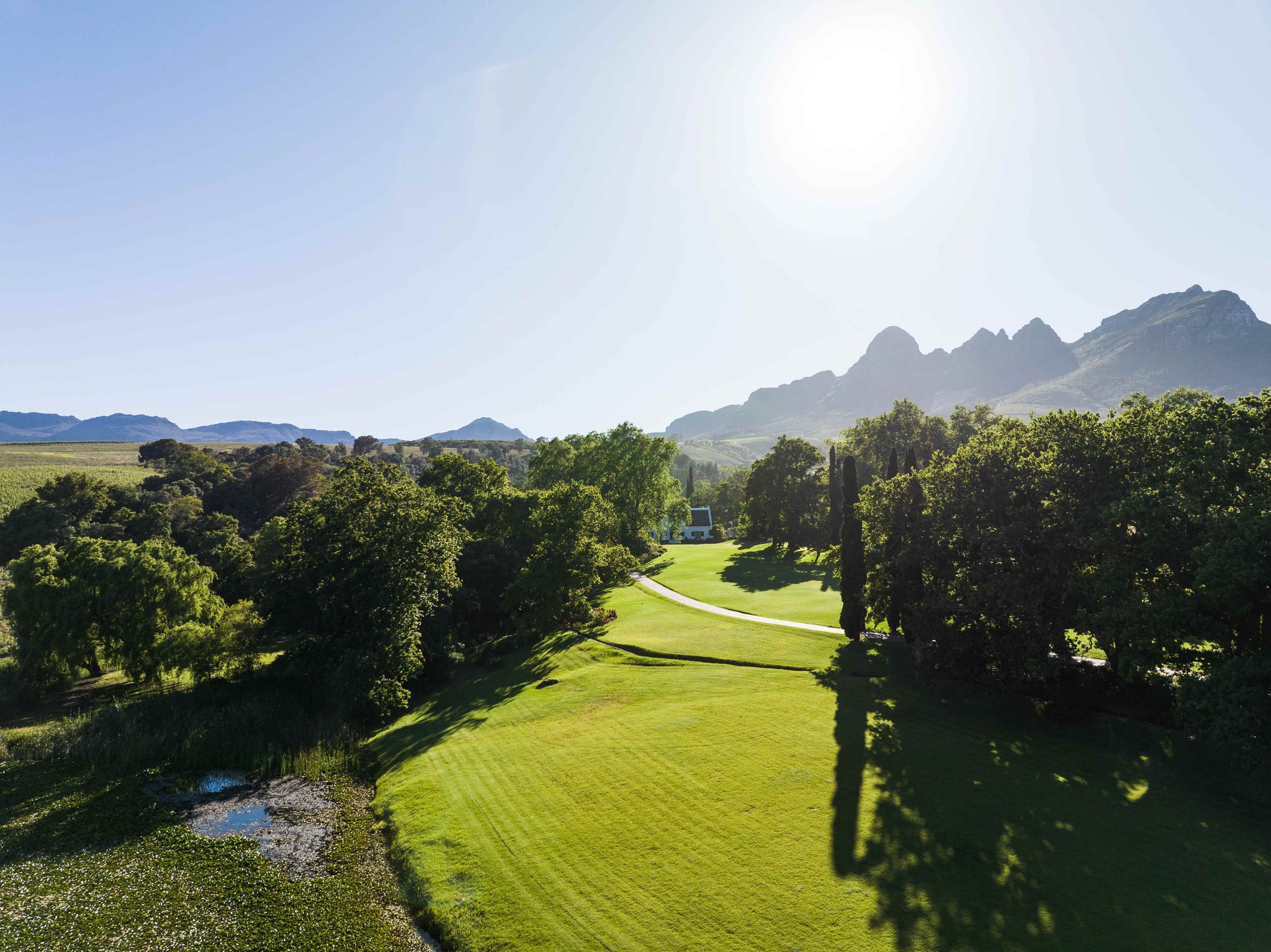 Aerial view of Navarre estate with sweeping lawns, cypress trees, and Helderberg mountains